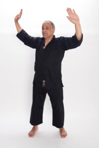 Sifu Ješe Gyatso oředvádí třetí z pohybů čchi-kung Orel v hnízdě s názvem Propínání křídel k severu a k jihu